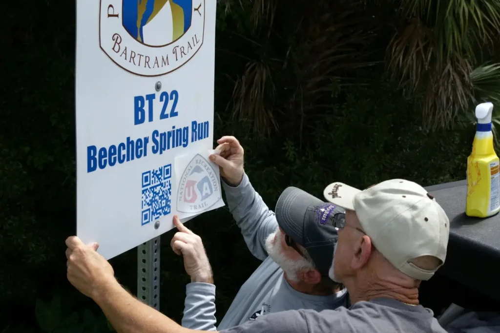 Ken and Sam applying the National Recreation Trail logo to a Bartram Trail site marker in the field in 2016